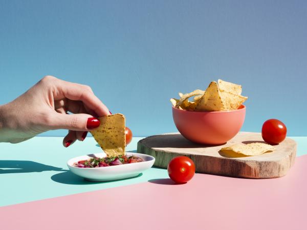 close up person with tortilla chips sauce