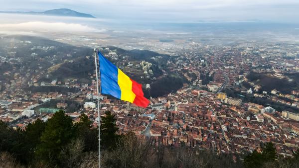 national flag top hill near barsov bare trees low clouds cityscape romania