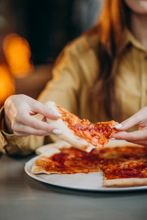 young pretty woman eating pizza bar