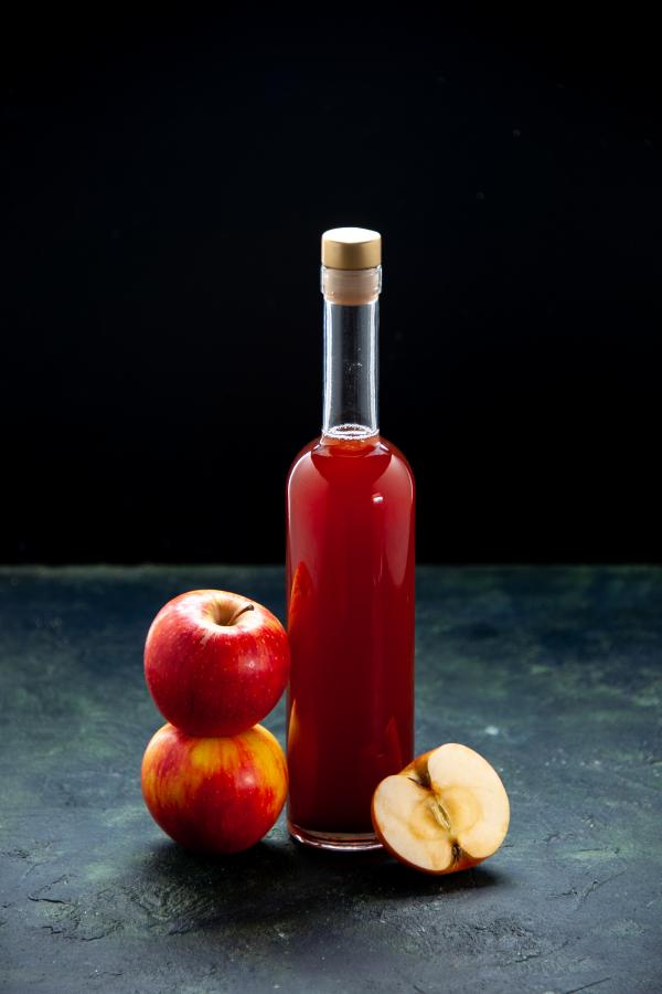 front view red apple sauce bottle dark surface